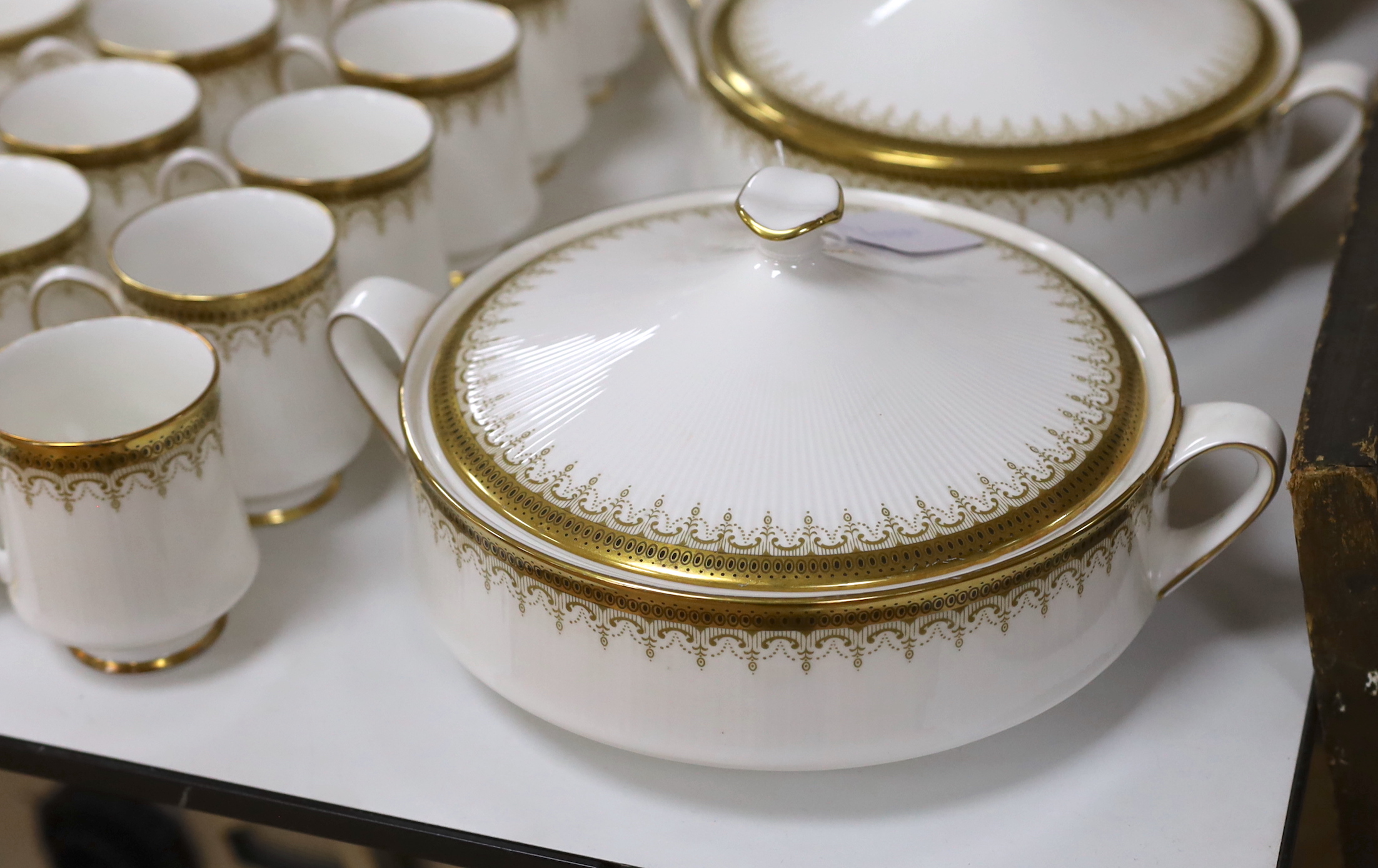 A Paragon Athena pattern blue and gilt tea service including three lidded tureens, oval platter and dinner plates, the largest 38cm wide
